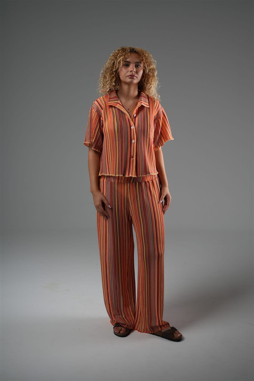 Model in the orange Arcobaleno striped knit shirt and trousers