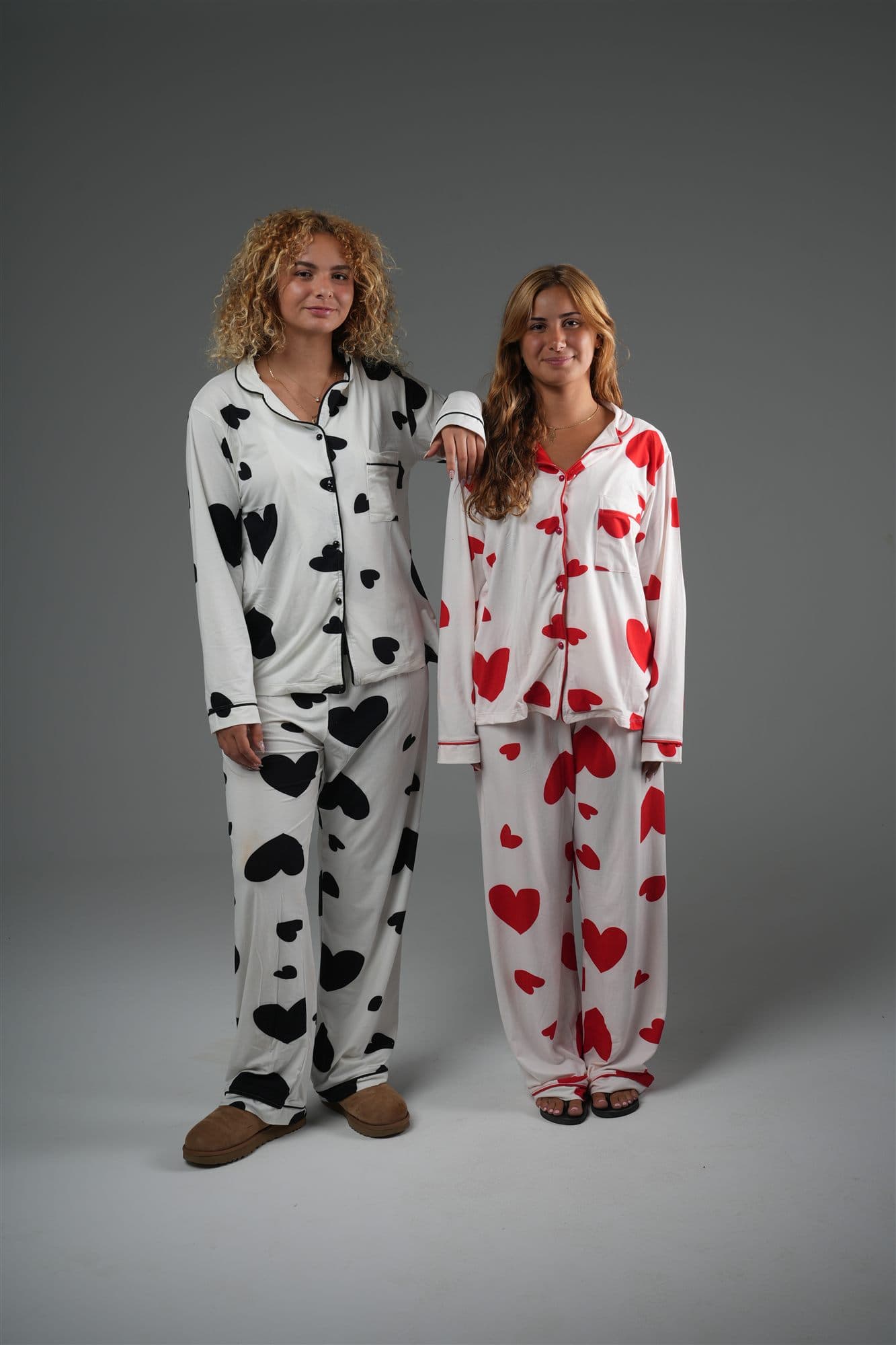 Two models in heart-print pyjama sets, one black on white, one red on white