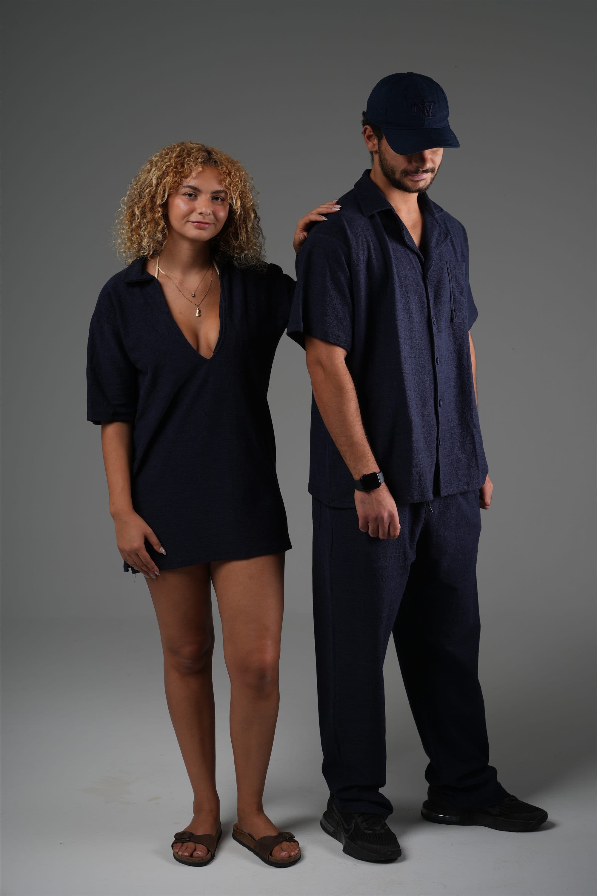 Two models in navy Riva terry: a polo dress, and a camp shirt with trousers